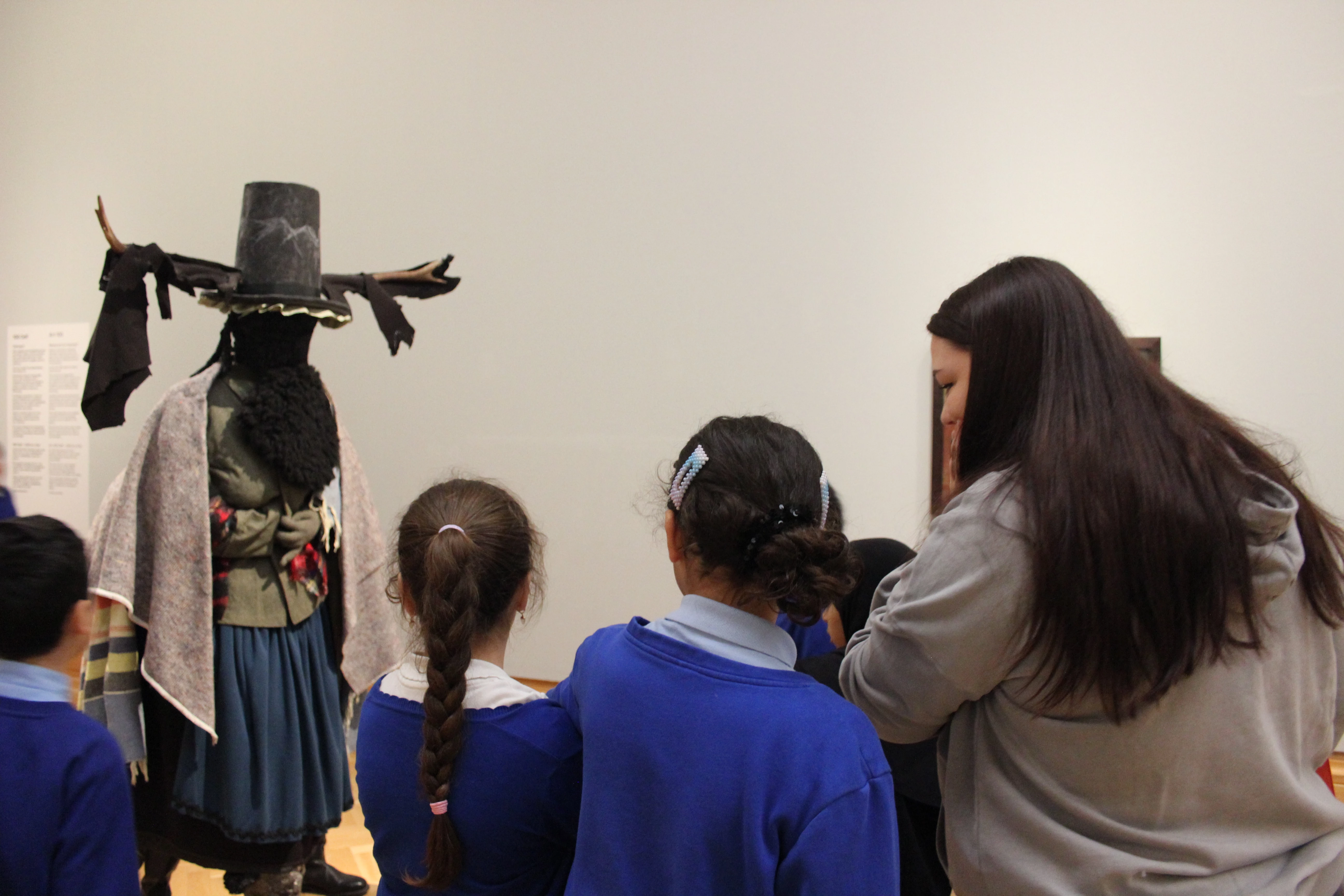 Llun o griw o blant ysgol yn edrych ar gerflun yn yr oriel