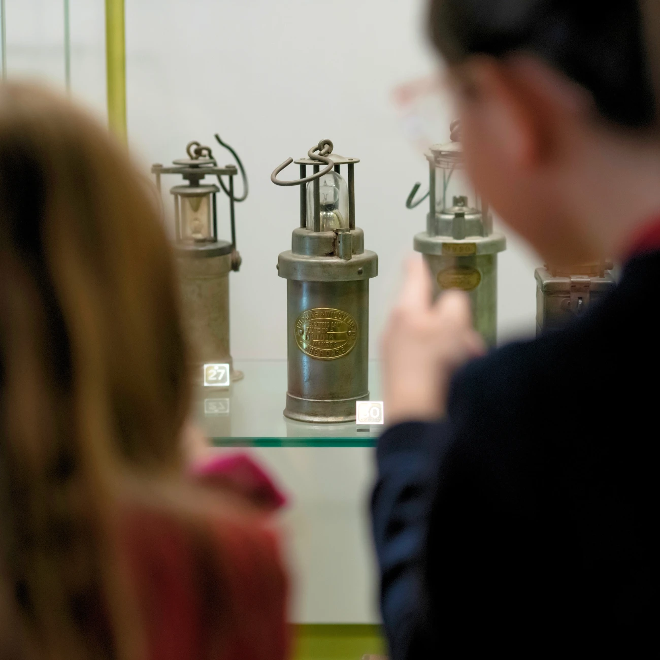 Dau ddisgybl yn edrych ar lamp glöwr