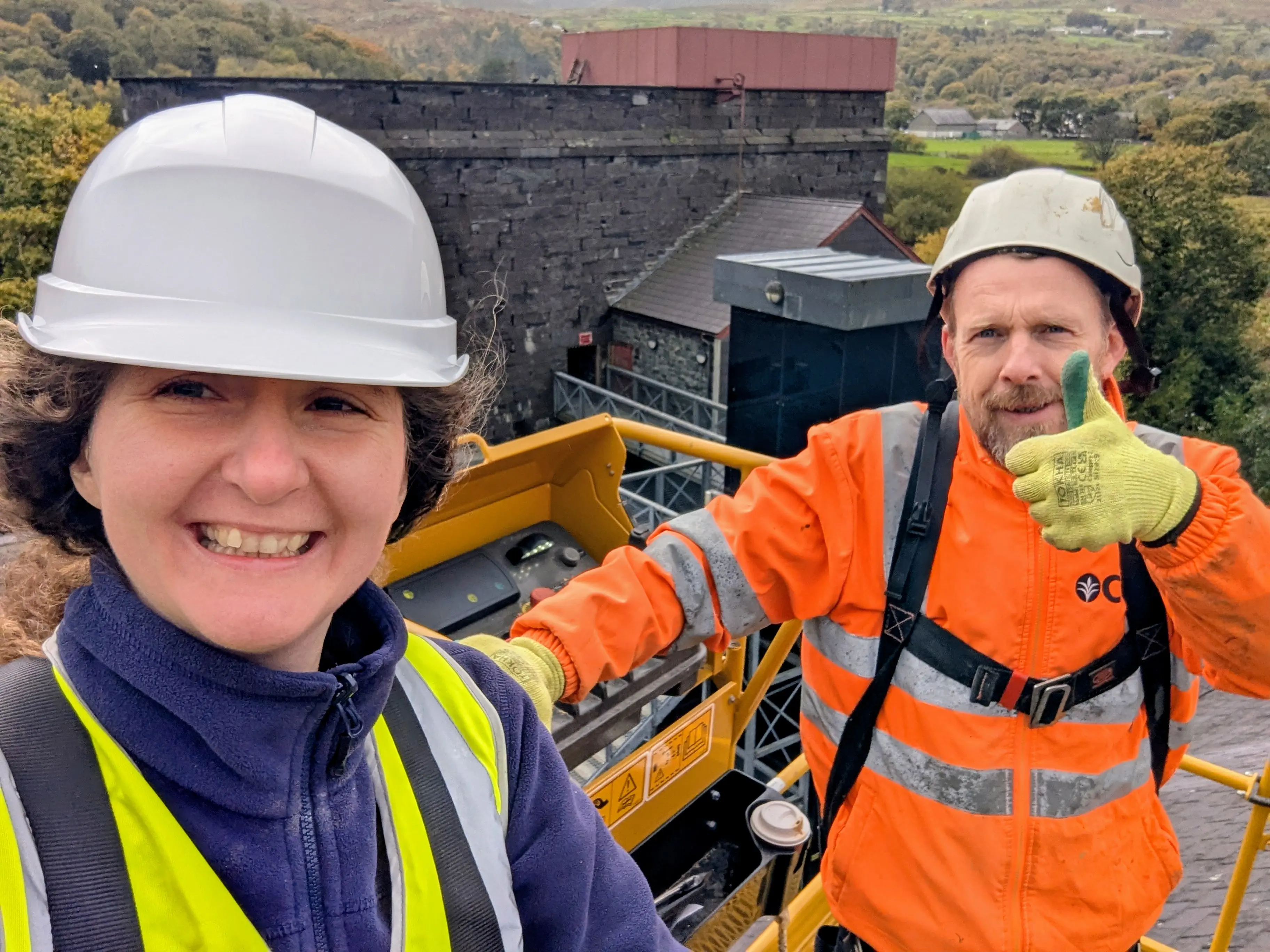 dyn a dynes mewn festiau hi- viz ar ben to yn Amgueddfa lechi Cymru